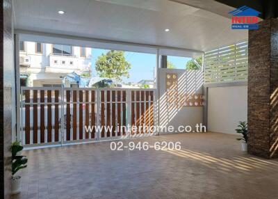 Covered patio with tiled floor and wooden gate