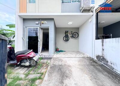 Front view of the property with a garage space and parked vehicles