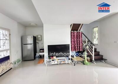 Living room interior with TV, fridge and stairs