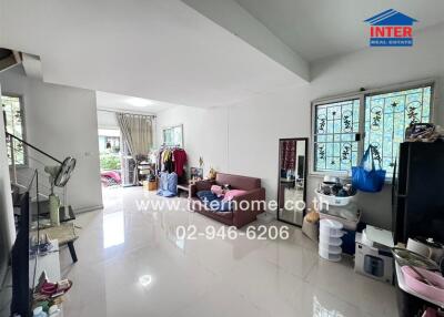 Spacious living room with large windows and a staircase