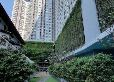 Exterior view of a high-rise residential building with greenery