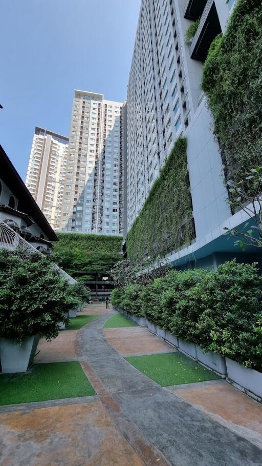 Exterior view of a high-rise residential building with greenery