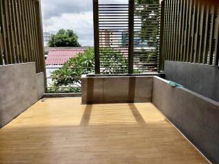 Spacious balcony with wooden flooring and modern railings