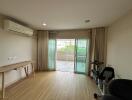 Living room with wooden floor, large window, and balcony