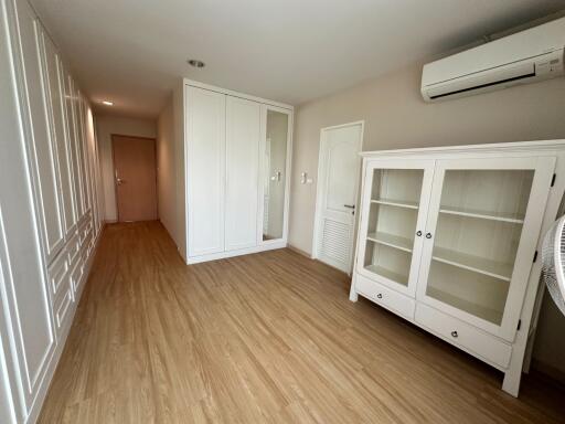 Spacious bedroom with wooden floor and built-in wardrobe