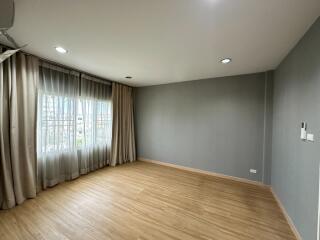 Empty bedroom with wooden flooring and large windows