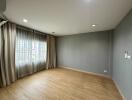 Empty bedroom with wooden flooring and large windows