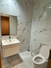 Modern bathroom with white marble tiles and fixtures