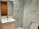 Modern bathroom with white marble tiles and fixtures