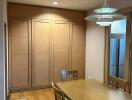 Dining room with wooden table, chairs, and cabinets