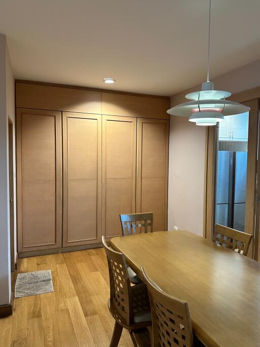 Dining room with wooden table, chairs, and cabinets