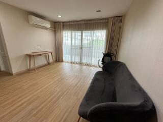 Spacious living room with a couch, table, and large windows