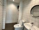 Modern bathroom with white tiled walls and fixtures