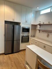 Modern kitchen with built-in appliances and wooden flooring