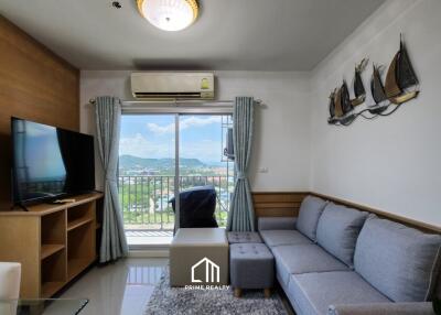 Living room with a sofa, TV, and balcony view