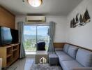 Living room with a sofa, TV, and balcony view