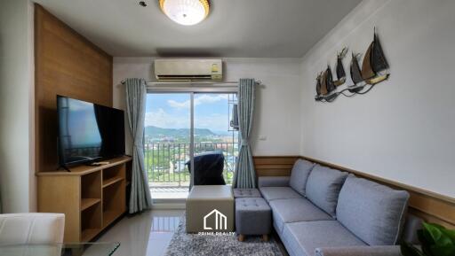 Living room with a sofa, TV, and balcony view