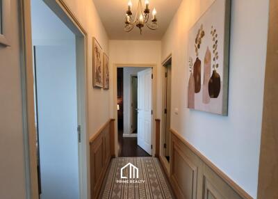 Hallway with wall art, chandelier, and doorways