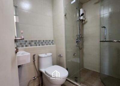 Modern bathroom with glass-enclosed shower, toilet, and wall-mounted sink