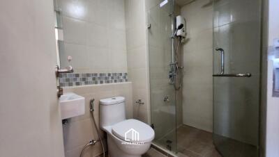 Modern bathroom with glass-enclosed shower, toilet, and wall-mounted sink