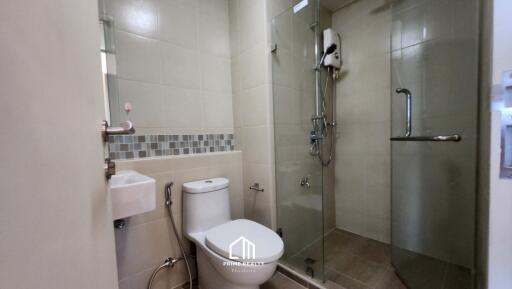 Modern bathroom with glass-enclosed shower, toilet, and wall-mounted sink