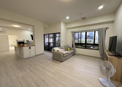 Modern living room with large windows and light wood flooring