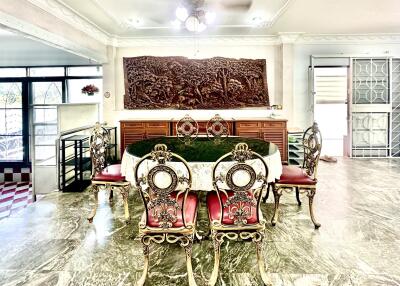 Elegant dining room with ornate furniture and large wooden wall carving