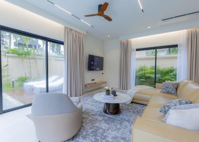 Modern living room with large windows, stylish furniture, and an outdoor view