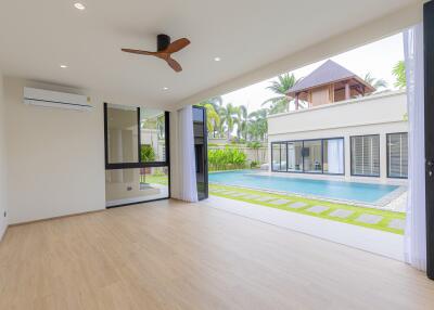 Spacious living room with view of a swimming pool and garden