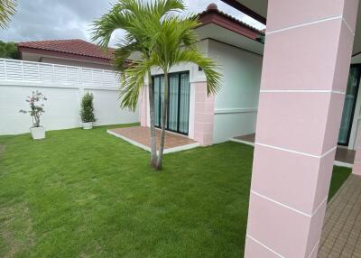 Exterior view of a well-maintained garden with patio and palm tree