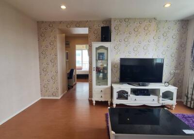 Spacious living room with TV and decorative wall