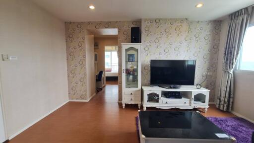 Spacious living room with TV and decorative wall