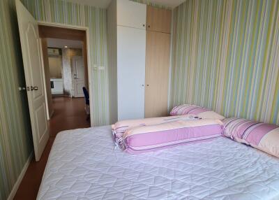 Bedroom with double bed, closet, and striped wallpaper