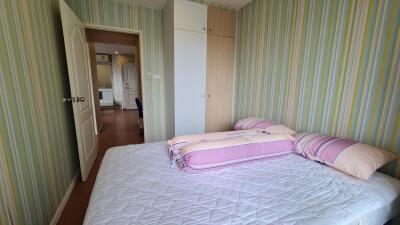 Bedroom with double bed, closet, and striped wallpaper