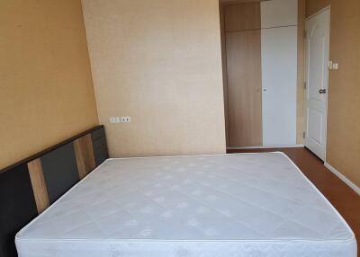 Empty bedroom with mattress and wardrobe