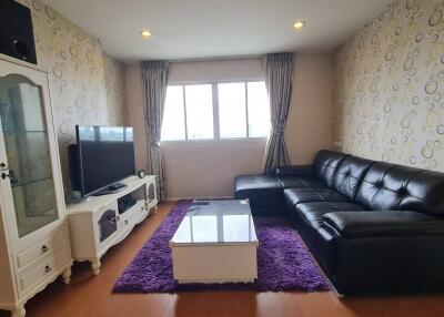 Living room with black leather couch and TV