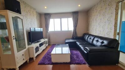 Living room with black leather couch and TV