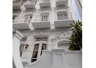 Facade of a multi-story building with ornate architectural details and balconies.