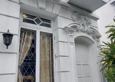 Elegant white building exterior with decorative balconies and a front entrance