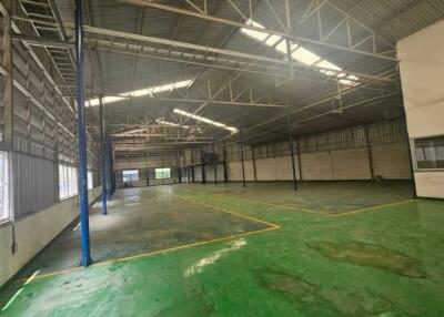 Spacious industrial warehouse with green flooring and high ceilings