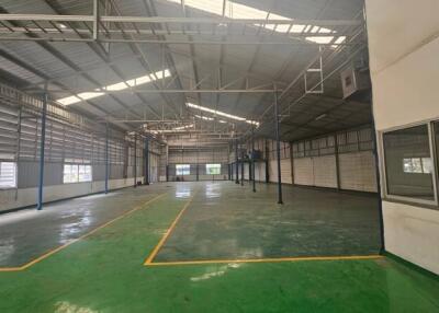 Spacious industrial warehouse with high ceilings and marked floor zones