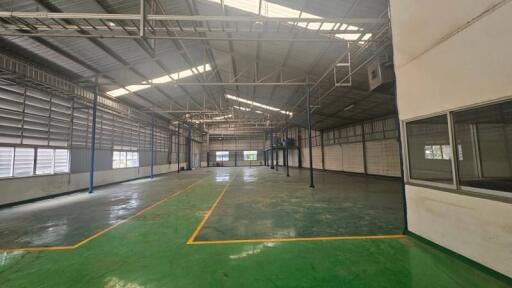 Spacious industrial warehouse with high ceilings and marked floor zones