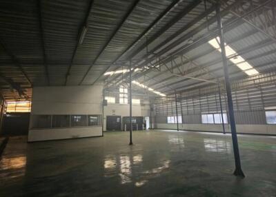 Large industrial warehouse interior with high ceilings and natural light.