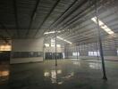 Large industrial warehouse interior with high ceilings and natural light.