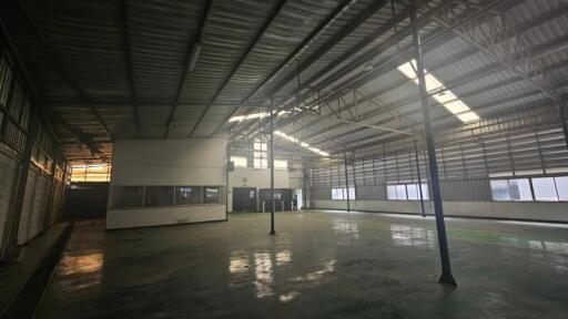 Large industrial warehouse interior with high ceilings and natural light.