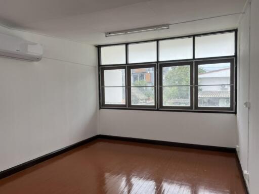 Well-lit bedroom with large windows and air conditioning