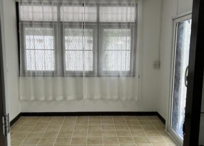 A small, empty room with windows and curtains