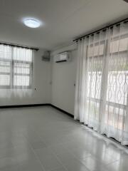 Bright living room with large windows and tile flooring