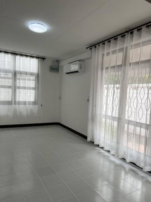 Bright living room with large windows and tile flooring