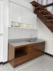 Modern kitchen with wooden cabinets and stairs